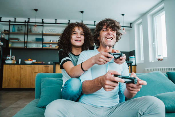 istock Father and son playing digital games at home 1276611217