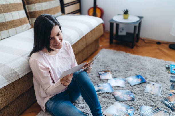 istock Woman looking photographs at home 1276611285