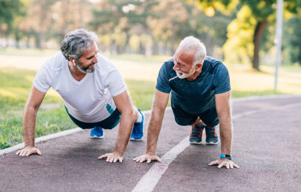 istock Smiling mature athletes doing push-ups in the park. 1276611666