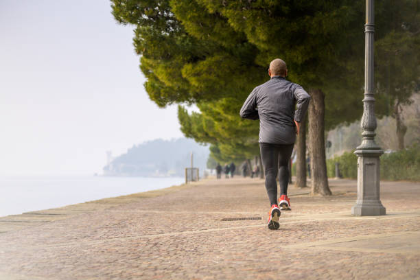 homme adulte moyen courant sur un grand sentier - distance running jogging running fog photos et images de collection