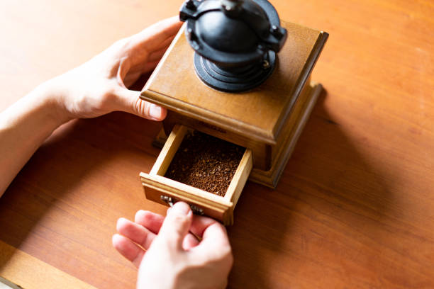 Close-up view of pouring ground coffee beans into a plate in a home kitchen