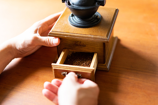 Brewing Coffee at Home - Taking the coffee powder from the coffee mill
Taken in natural light. Wooden table.