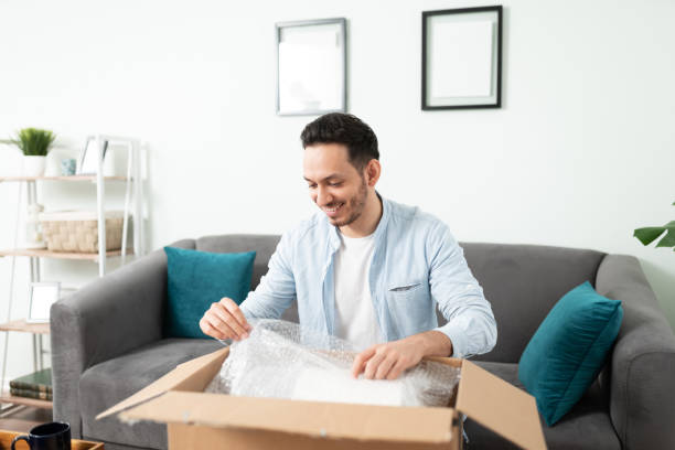 istock Hispanic man unpacking a delivery box 1276617884