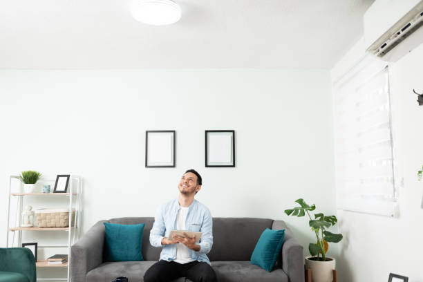 homem acendendo as luzes em uma casa inteligente - patch of light - fotografias e filmes do acervo