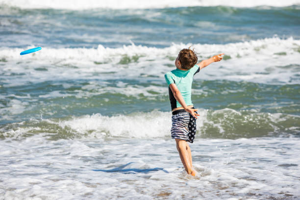 istock Father and son playing frisbee at the beach 1276617990