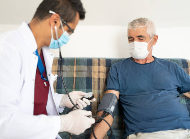 hälsoarbetare mäter blodtryck till äldre patient hemma - blodtryck orolig bildbanksfoton och bilder
