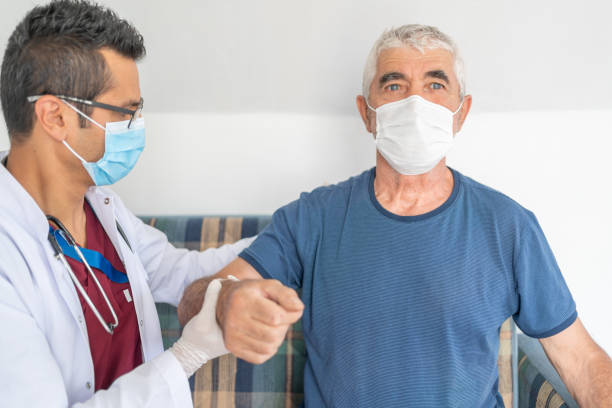 istock Old man with protective face mask is having physical therapy at home 1276618949