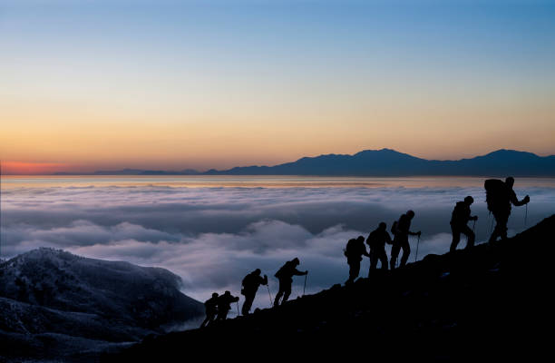 silhuetas de caminhantes ao nascer do sol - climbing clambering mountain silhouette - fotografias e filmes do acervo