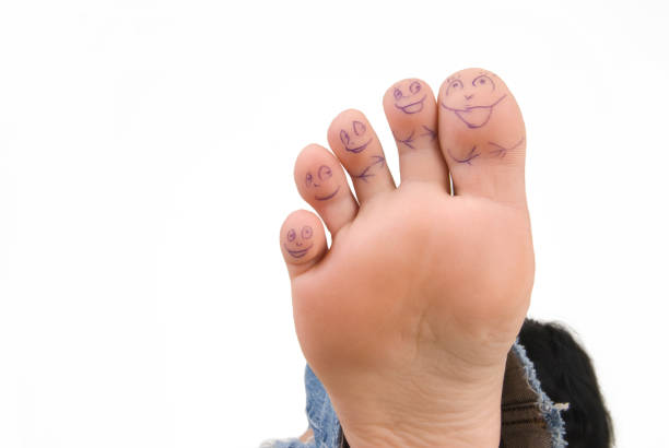 istock toes on a female leg with painted faces on a white background 1276620219