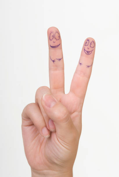 istock fingers on a female hand with painted faces on a white background 1276620424