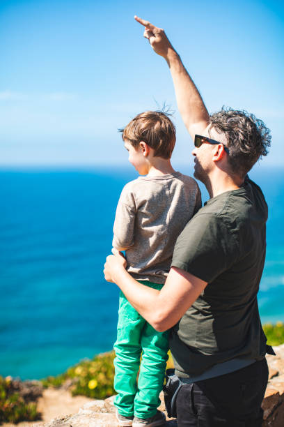 istock Father and son walking at the beach together 1276621632