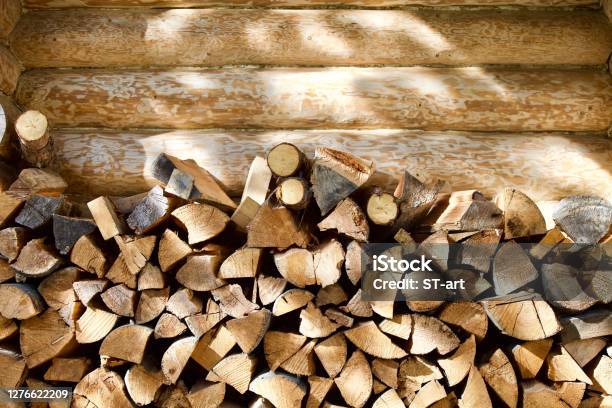 Stacked Firewood Near The Wall Of A Log Village House Closeup Stock Photo - Download Image Now