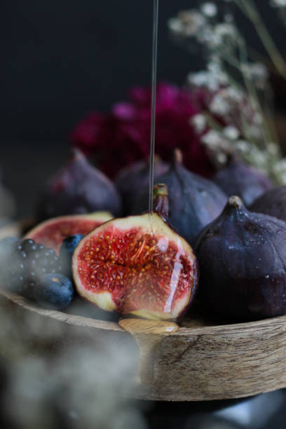 Pouring Honey on Figs in rustic kitchen with moody dark light