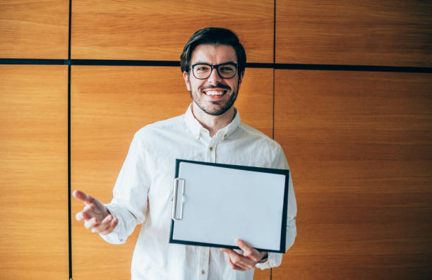 istock Young man showing a blank paper page. 1276625125