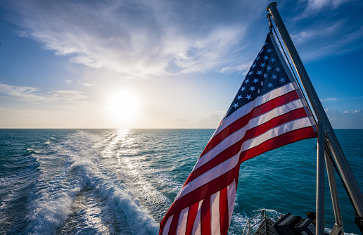 istock American Flag and Sunrise Over Gulf of Mexico 1276628084