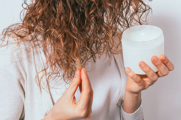 le mani della femmina applicano olio di cocco cosmetico - end product foto e immagini stock