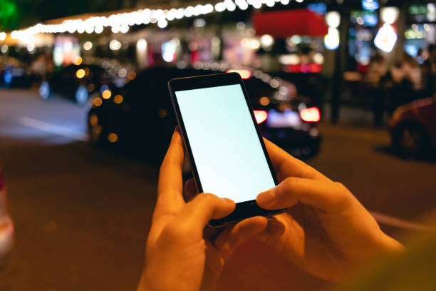 istock Mobile phone in female hands at night 1276628275