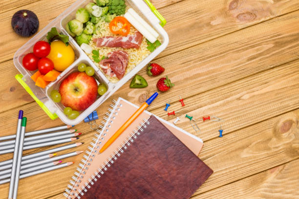 szkolne pudełko na lunch ze smacznym jedzeniem i papeterii na drewnianym biurku - strawberry plant audio zdjęcia i obrazy z banku zdjęć