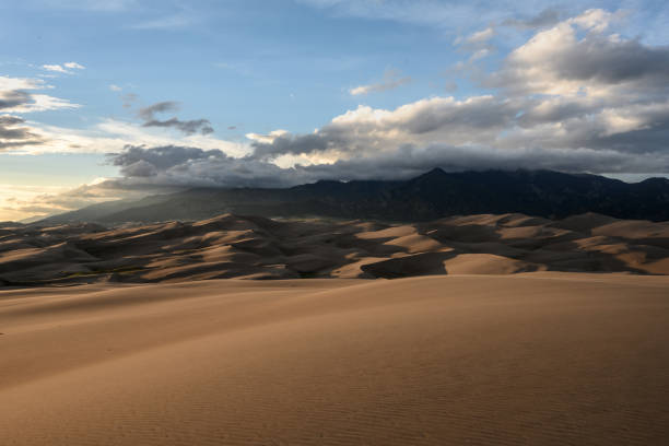 istock Mountain Peaks Hide in Clouds Above Sand Dunes 1276630180