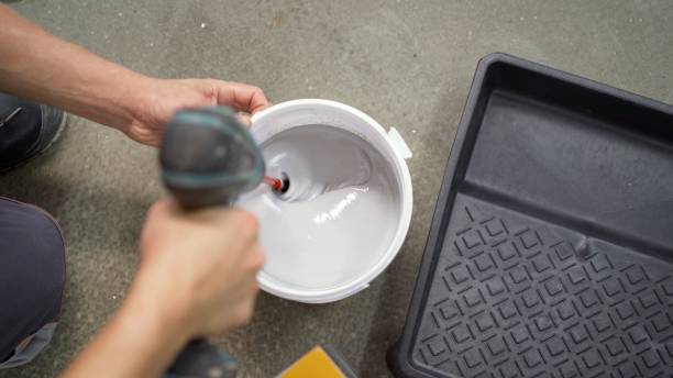 istock Drill paddle mixer on a bucket with white paint, DIY tools and accessory. The white paint is mixed in a bucket with a drill. 1276631429