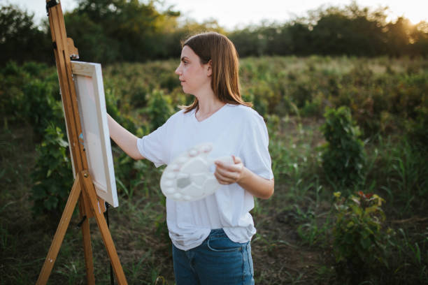 istock Creative woman painting in nature 1276631745