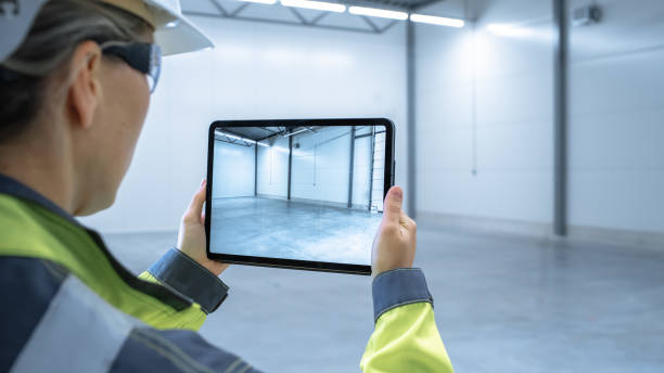 istock Industry 4.0 Modern Factory: Female Engineer Uses Digital Tablet Computer with Augmented Reality Software Visualizing of Manufacturing Plant Room Mapping, Factory Layout. Concept Shot Suitable for AR. 1276633097