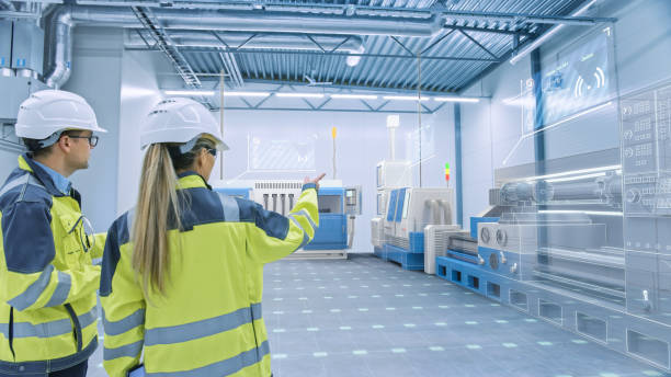 istock Two Engineers Standing and Talking in Factory Workshop with Augmented Reality 3D Models CNC Machinery Production Line. Industry 4.0 Graphics Visualization in Factory. VFX Special Graphics Effects 1276633106