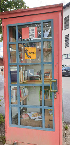 vecchia cabina telefonica piena di libri - telephone booth telephone panoramic red foto e immagini stock