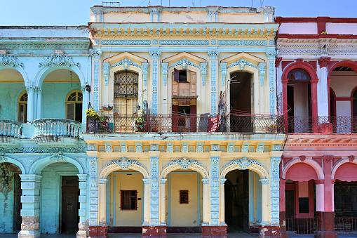 Front view of colorful, run-down residential building facades with balconies in Havana, Habana, Cuba