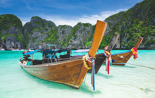Andaman sea Phi phi leh maya island and longtail boat with sun lighting.