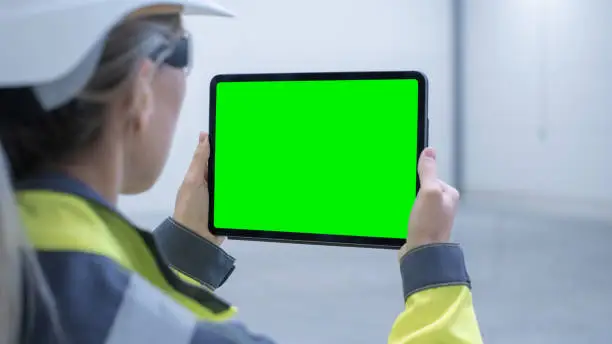 Industry 4.0 Modern Factory: Female Engineer Uses Digital Tablet Computer with Green Screen Mock-up Template Suitable for Visualizing Augmented Reality Software of Mapping Manufacturing Plant Room.