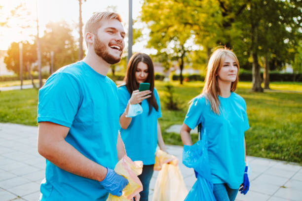 istock Volunteers with garbage bags cleaning up garbage outdoors - ecology concept. 1276638222