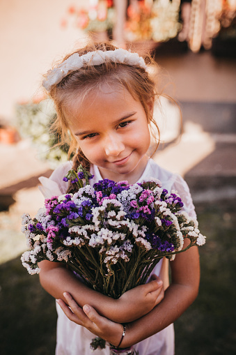 Cute Little girl holding purple flowers for her mother