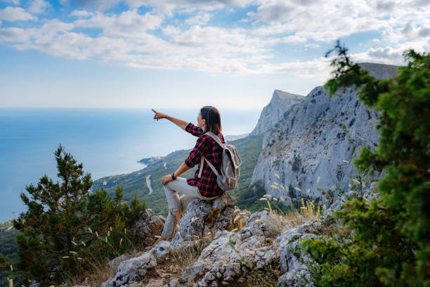 istock woman hiker enjoy the view at sunset mountain peak cliff 1276641021