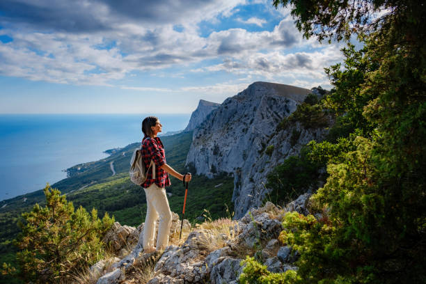 istock Fit female hiker with backpack standing on a rocky mountain ridge 1276641035