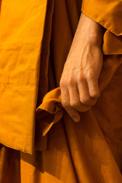 istock Close-up of monk hands holding his robes. 1276641694