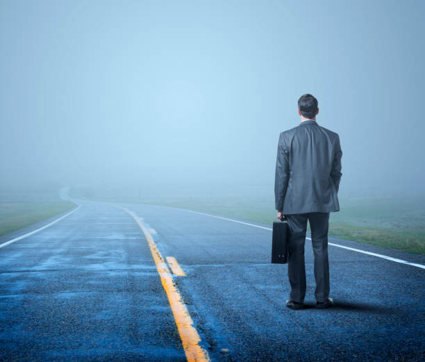istock Businessman Stands On Wet And Misty Road 1276642379