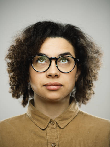 istock Studio portrait of young woman with blank expression looking up 1276642530