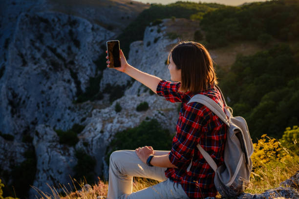 istock woman hiker enjoy the view at sunset mountain peak cliff 1276643904