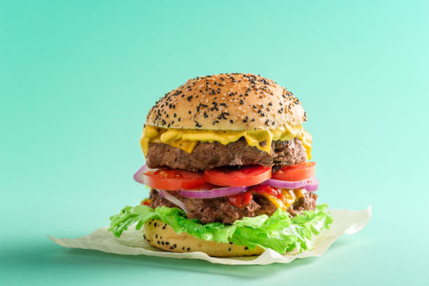 istock Burger isolated on a green background. Homemade large cheeseburger 1276645321