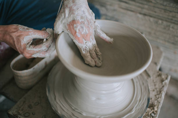 istock asian chinese active senior man Potter working at his workshop with spinning pottery wheel 1276650766