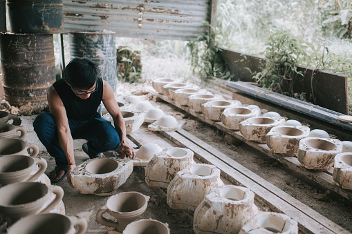 asian chinese potter cracking the mold and retrieve the pottery clay vase from the mold after the oven process