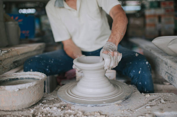 istock asian chinese active senior man Potter working at his workshop with spinning pottery wheel 1276650867