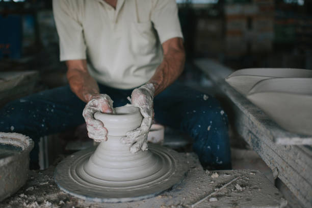 istock asian chinese active senior man Potter working at his workshop with spinning pottery wheel 1276650896