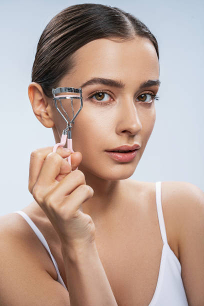 istock Young charming model holding eyelashes curler in hand 1276652092