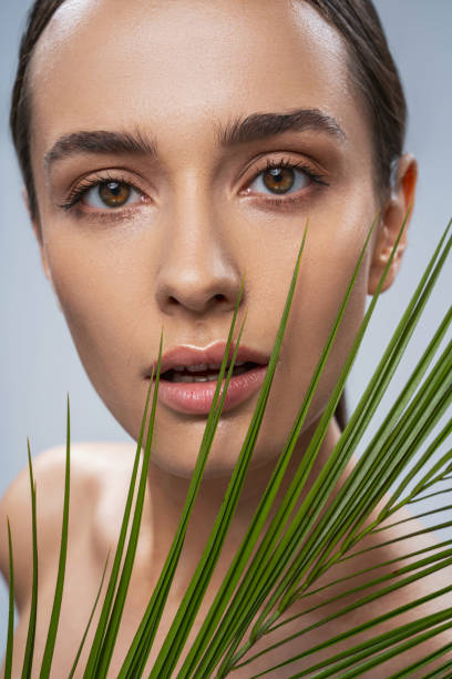 istock Charming dark eyes woman holding green leaf 1276652109