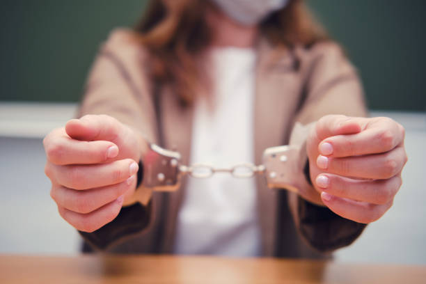 School teacher with handcuffs on hand, concept of bondage during quarantine School teacher with handcuffs on hand, concept of bondage during quarantine arrest photos stock pictures, royalty-free photos & images