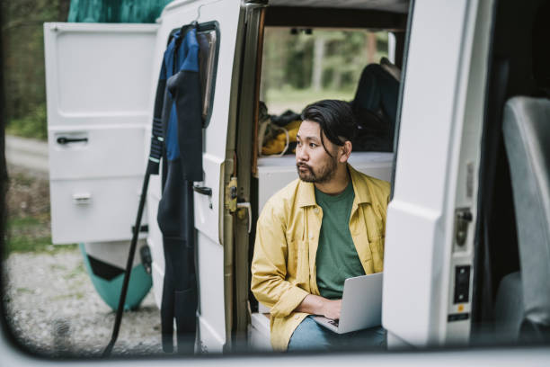 istock Man working on his laptop in mini van 1276654095