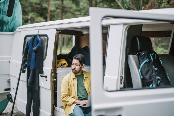 istock Man working on his laptop in mini van 1276654099