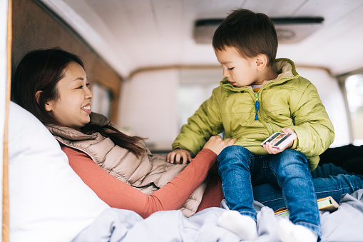 Mother and child laying in self built camper van
